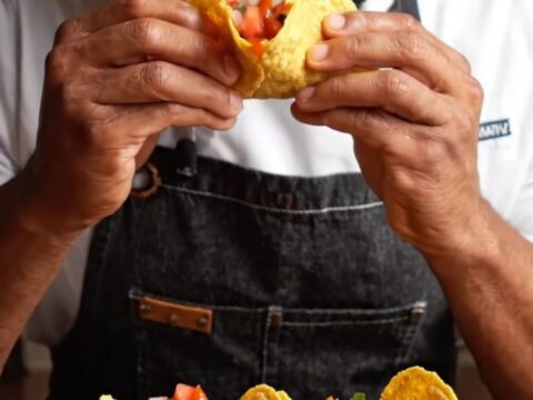 Cheesy crispy chicken tacos with pico and spicy sauce on a platter
