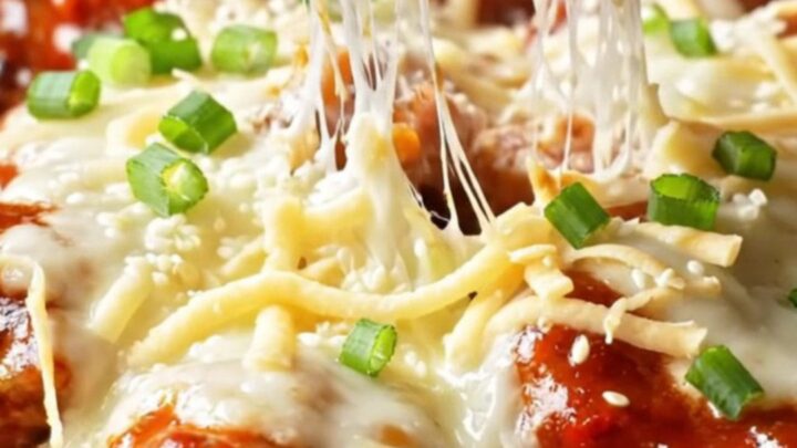 Skillet of Korean cheesy fire chicken with bubbling mozzarella and charred edges