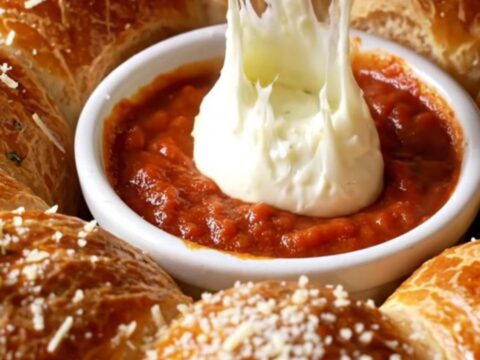 Golden pull-apart brioche wreath with melted cheese and garlic butter, served with marinara sauce.