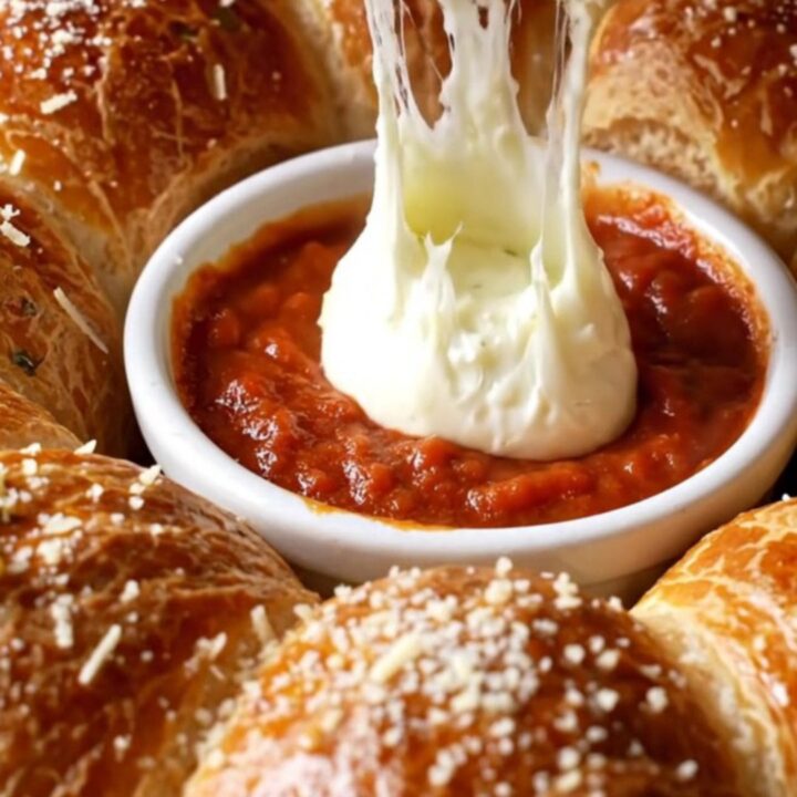 Golden pull-apart brioche wreath with melted cheese and garlic butter, served with marinara sauce.