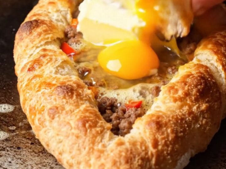 Boat-shaped Turkish pide with blistered crust, spiced beef, melted butter, and glossy egg yolk