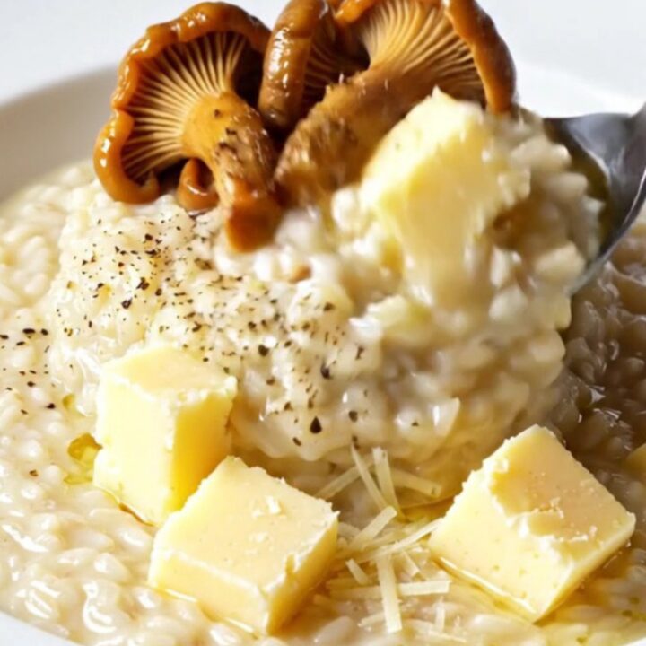 Creamy wild mushroom and Taleggio risotto topped with seared chanterelles and truffle oil in a skillet
