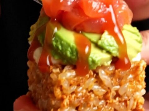 Golden crispy rice cakes topped with avocado, spicy salmon tartare, and jalapeño wheels