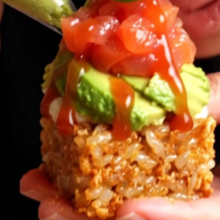 Golden crispy rice cakes topped with avocado, spicy salmon tartare, and jalapeño wheels