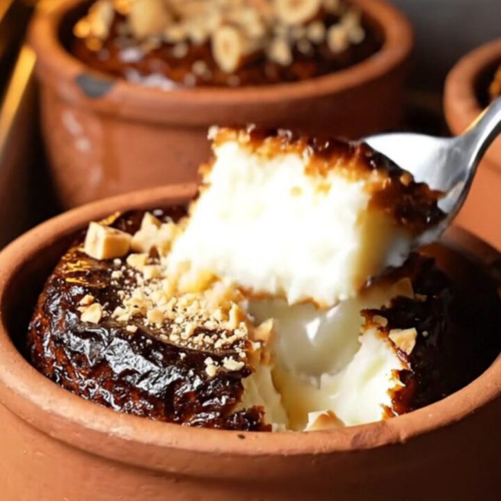 Cracked caramelized top of Turkish rice pudding in a clay bowl