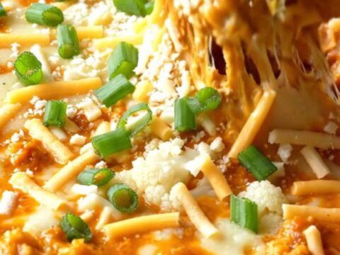 Skillet of cheesy buffalo cauliflower dip with toasted baguette slices