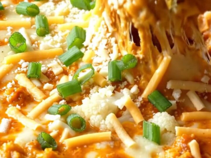 Skillet of cheesy buffalo cauliflower dip with toasted baguette slices