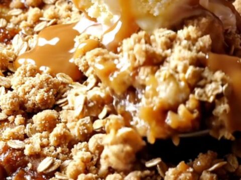 Cast iron skillet apple crisp with golden oat streusel, topped with vanilla ice cream and salted caramel drizzle.