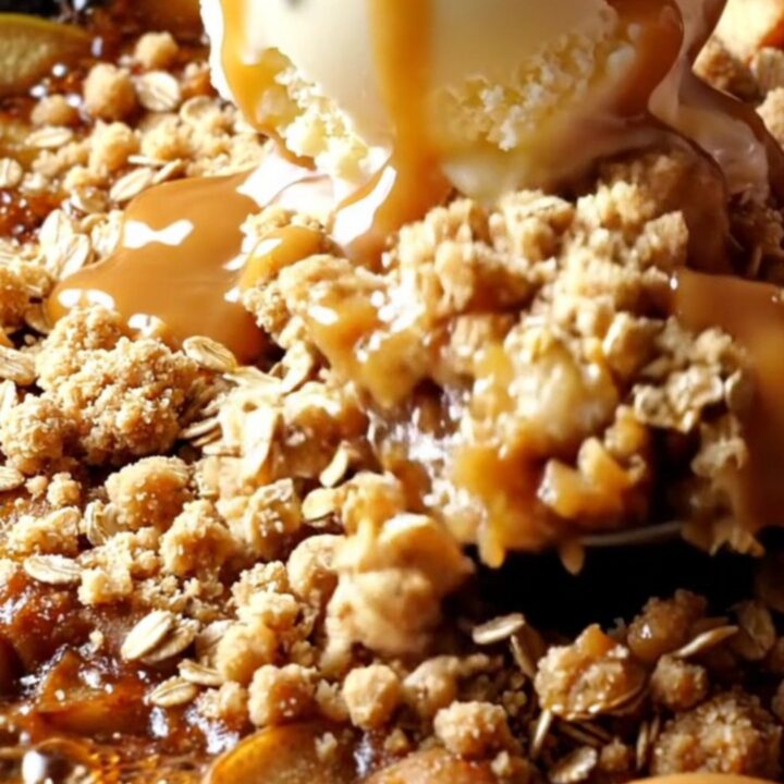 Cast iron skillet apple crisp with golden oat streusel, topped with vanilla ice cream and salted caramel drizzle.