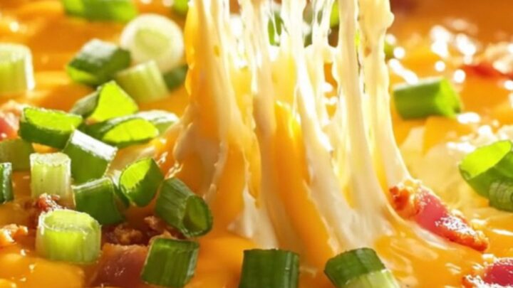 Loaded skillet baked potato dip with melted cheddar and bacon, served hot with potato chips.