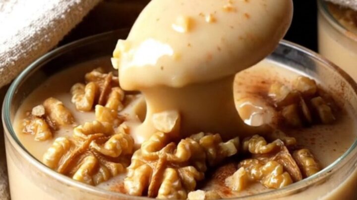 A glass bowl of Turkish fig milk pudding topped with cinnamon and chopped walnuts