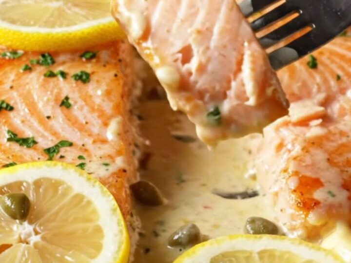 Crispy-skinned salmon fillets in a creamy lemon caper sauce, garnished with parsley