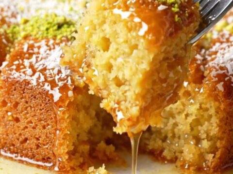 Turkish Revani cake with lemon syrup, topped with coconut and pistachios, in a baking dish