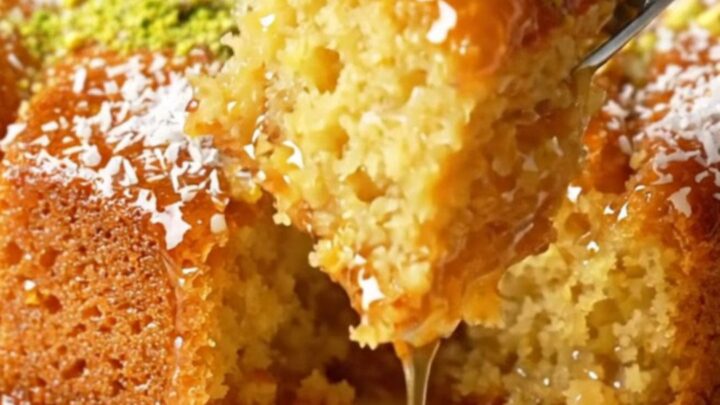 Turkish Revani cake with lemon syrup, topped with coconut and pistachios, in a baking dish