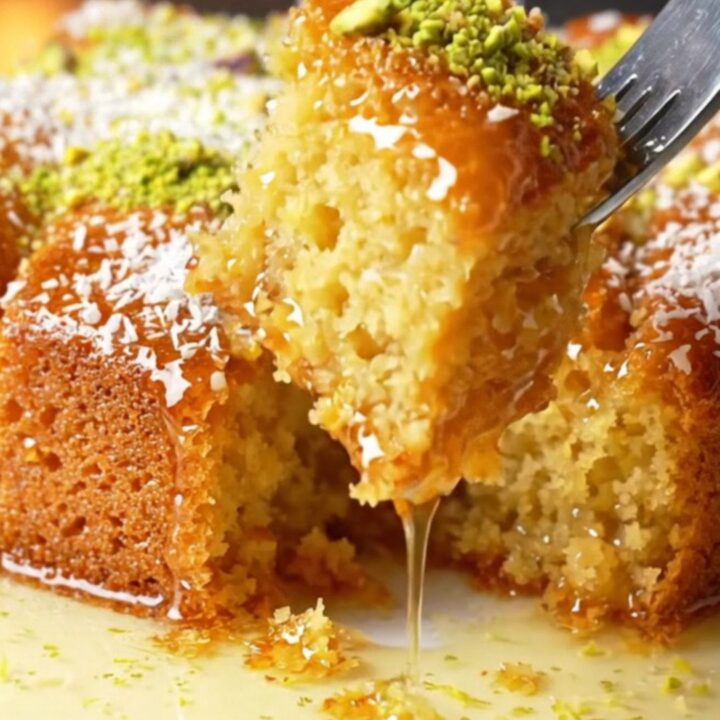 Turkish Revani cake with lemon syrup, topped with coconut and pistachios, in a baking dish