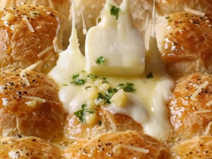 Golden pull-apart dinner rolls with melted cheese stretching between them