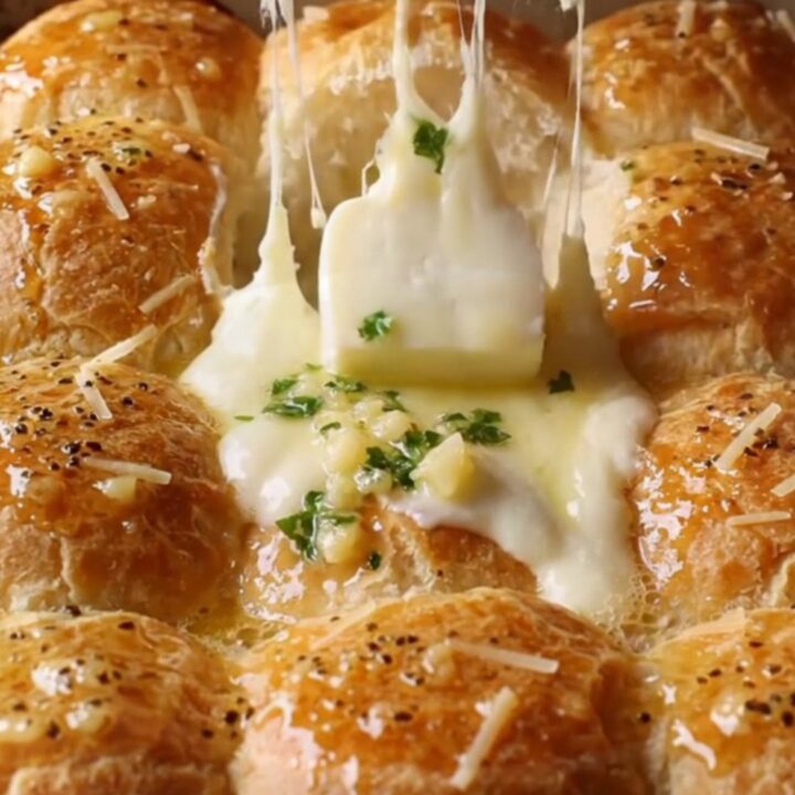 Golden pull-apart dinner rolls with melted cheese stretching between them