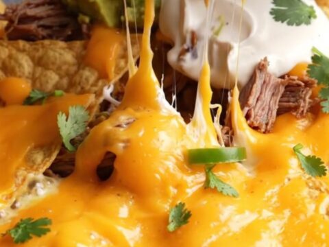 Loaded skillet nachos with smoked brisket, molten queso, and toppings