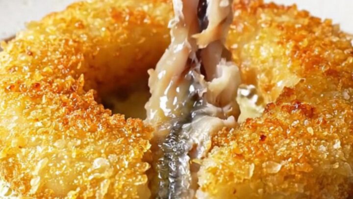 Golden pinwheel of crispy cornmeal-crusted anchovies in a skillet