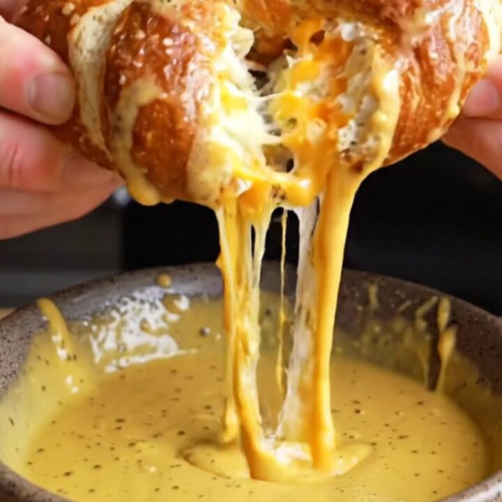 Golden brown pretzels stuffed with cheese, with a honey mustard dip on the side