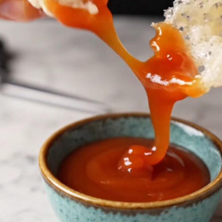 Crispy rice paper nori chips piled on a plate with sweet chili sauce