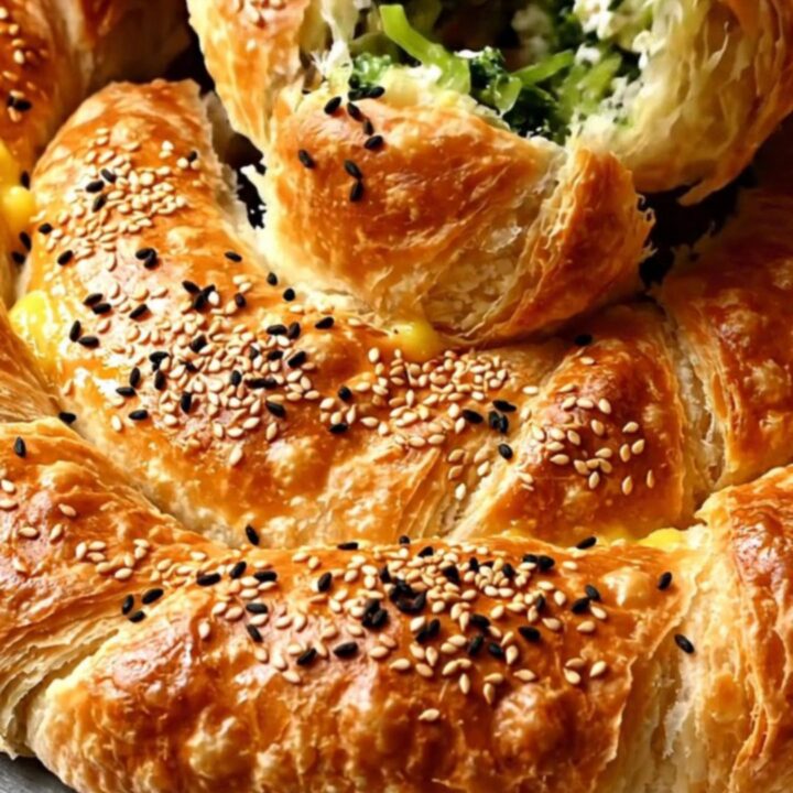 A golden spiral borek with sesame seeds, sliced to show spinach and feta filling.