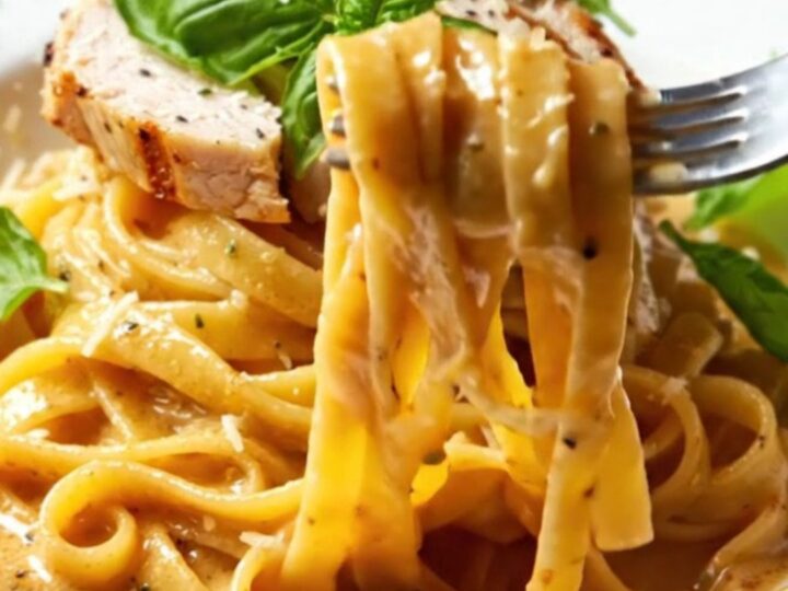 Creamy fettuccine with sun-dried tomatoes and grilled chicken, topped with fresh basil
