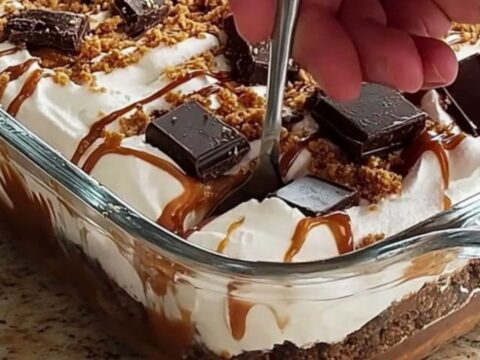 A clear glass dish filled with layers of white whipped cream and golden caramel