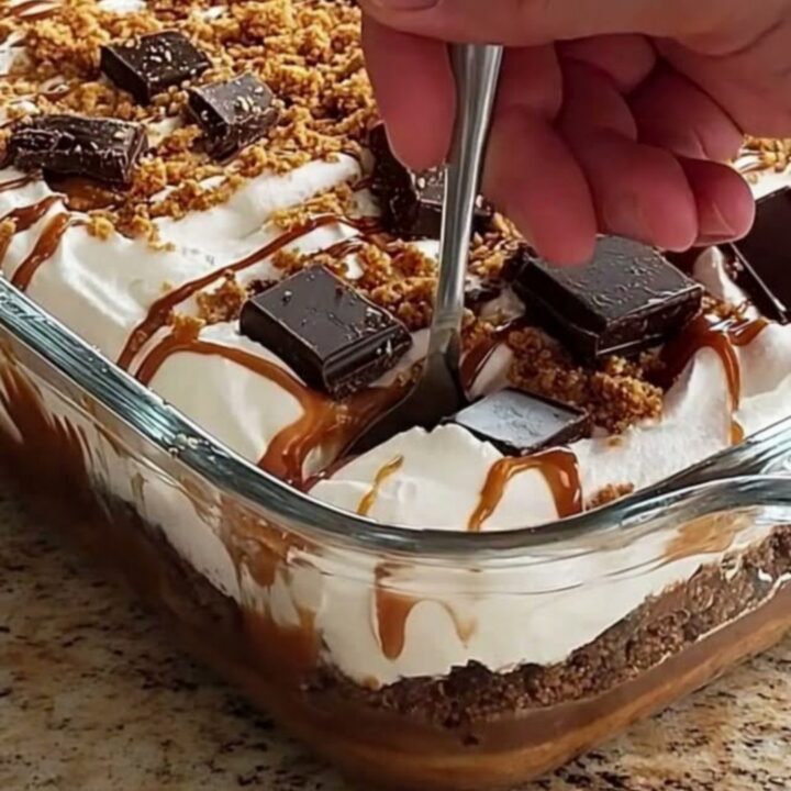 A clear glass dish filled with layers of white whipped cream and golden caramel