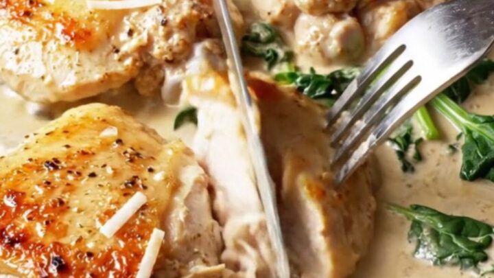 Golden chicken thighs in a creamy Tuscan sauce with sun-dried tomatoes and spinach in a cast iron skillet