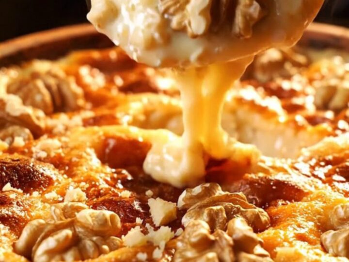 Warm baked tahini halva in a clay dish, caramelized top with crushed walnuts