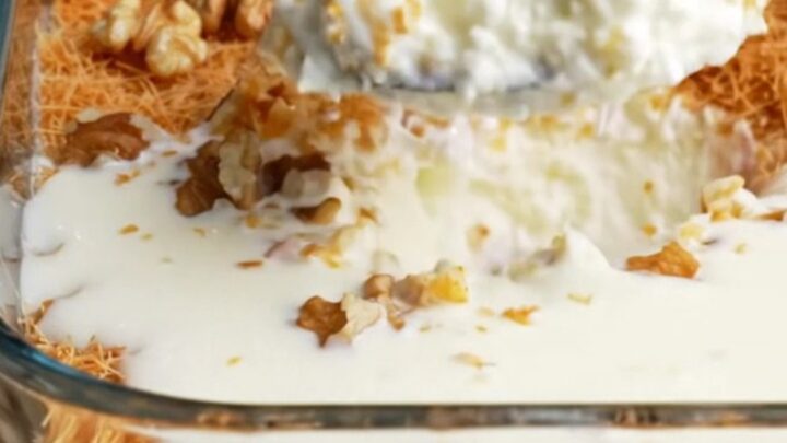 A glass dish of Turkish Kadayıflı Muhallebi with golden crispy kadayıf and walnuts on top, creamy pudding visible beneath.