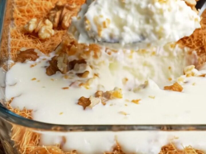 A glass dish of Turkish Kadayıflı Muhallebi with golden crispy kadayıf and walnuts on top, creamy pudding visible beneath.