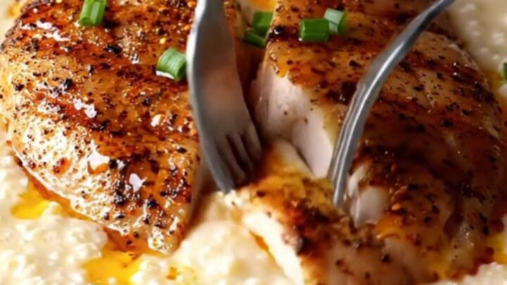 Blackened chicken slices over creamy white cheddar grits with spiced butter drizzle and chives