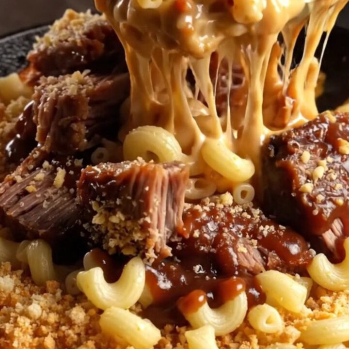 Bubbling cast iron skillet with smoked brisket mac and cheese, topped with golden panko and barbecue drizzle