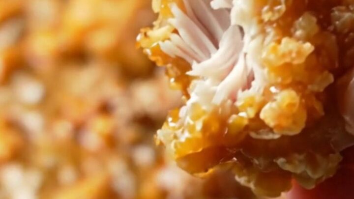 Crispy Korean honey butter popcorn chicken in a bowl, glazed and sprinkled with sesame seeds