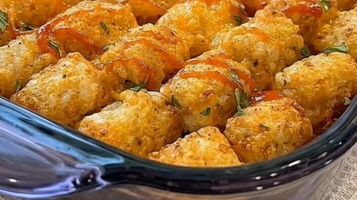A rectangular glass baking dish filled with golden-brown tater tots arranged in neat rows