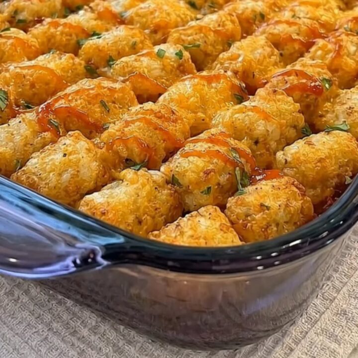A rectangular glass baking dish filled with golden-brown tater tots arranged in neat rows