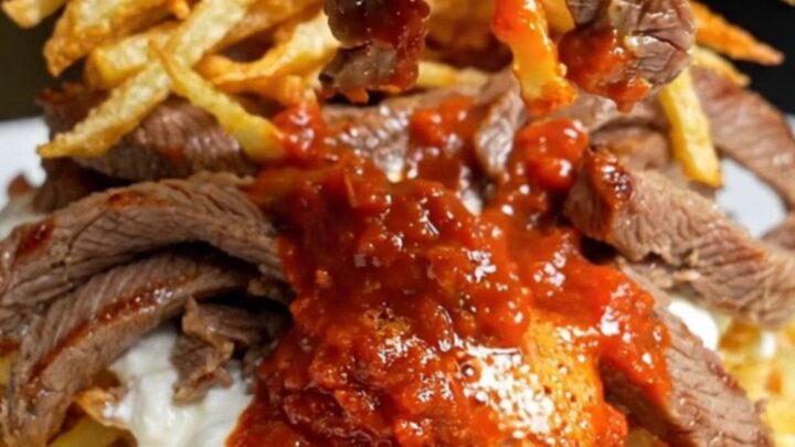 Turkish Çökertme Kebabı plated with crispy matchstick potatoes, garlic yogurt, and tomato-butter sauce