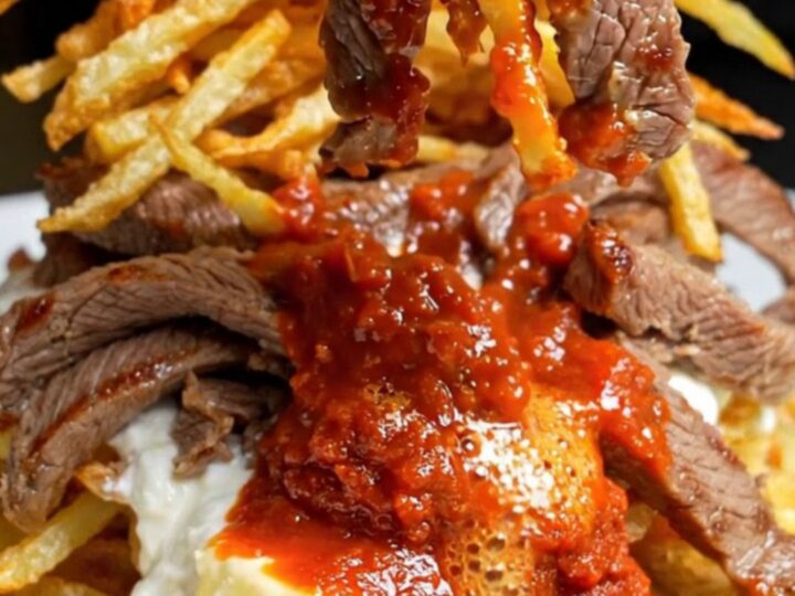 Turkish Çökertme Kebabı plated with crispy matchstick potatoes, garlic yogurt, and tomato-butter sauce