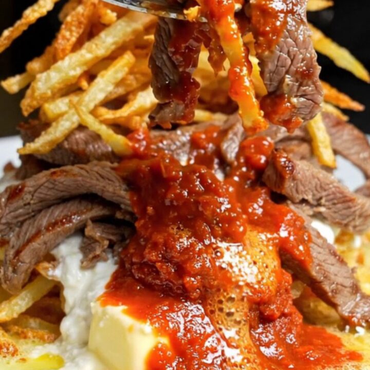 Turkish Çökertme Kebabı plated with crispy matchstick potatoes, garlic yogurt, and tomato-butter sauce