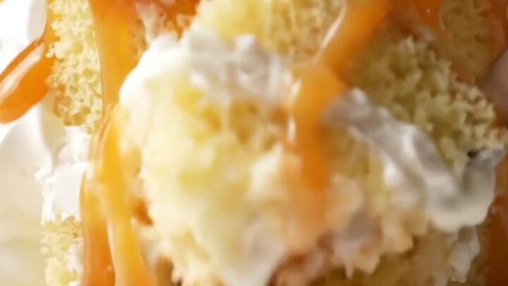 A square of Turkish Trileçe with amber caramel and whipped cream, fork lifting a bite