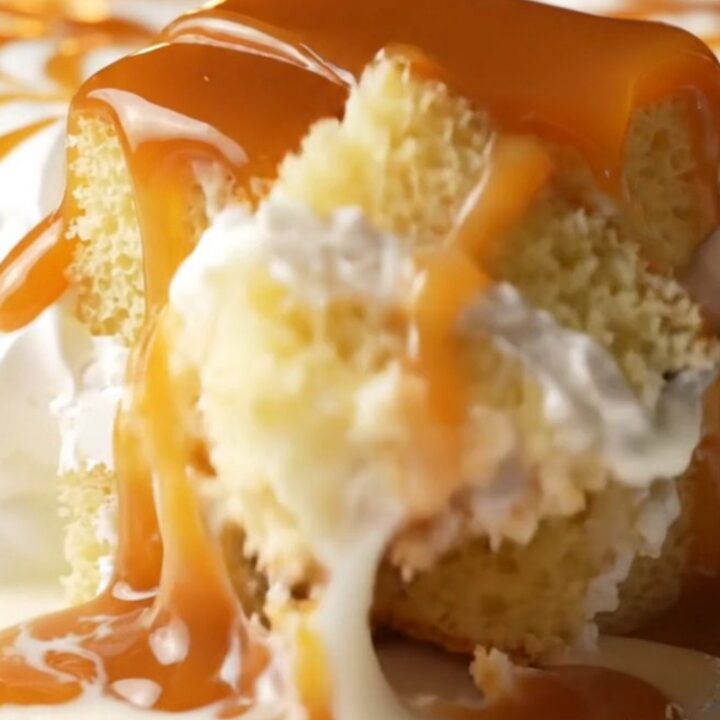 A square of Turkish Trileçe with amber caramel and whipped cream, fork lifting a bite