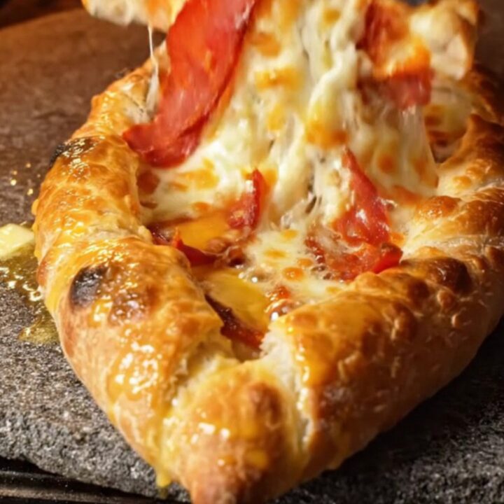 Crispy Turkish pide with melted cheese and sucuk, sliced and pulling cheese