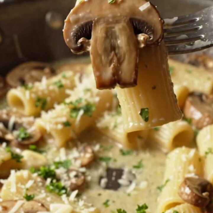 Creamy Boursin mushroom pasta in a skillet, with rigatoni coated in a herb-speckled sauce and golden mushrooms.