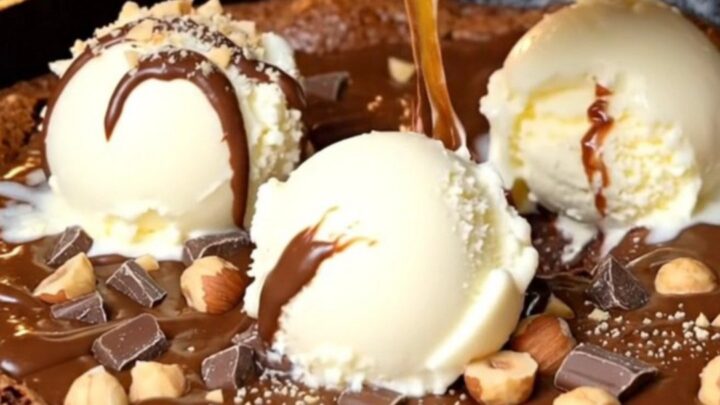 Warm skillet brownie with a molten hazelnut center and vanilla ice cream melting on top