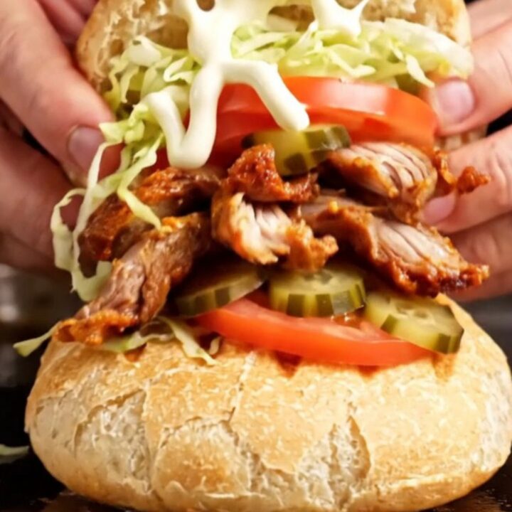 A Turkish chicken döner wrap with crispy chicken slices, lettuce, tomatoes, and pickles in toasted tombik bread