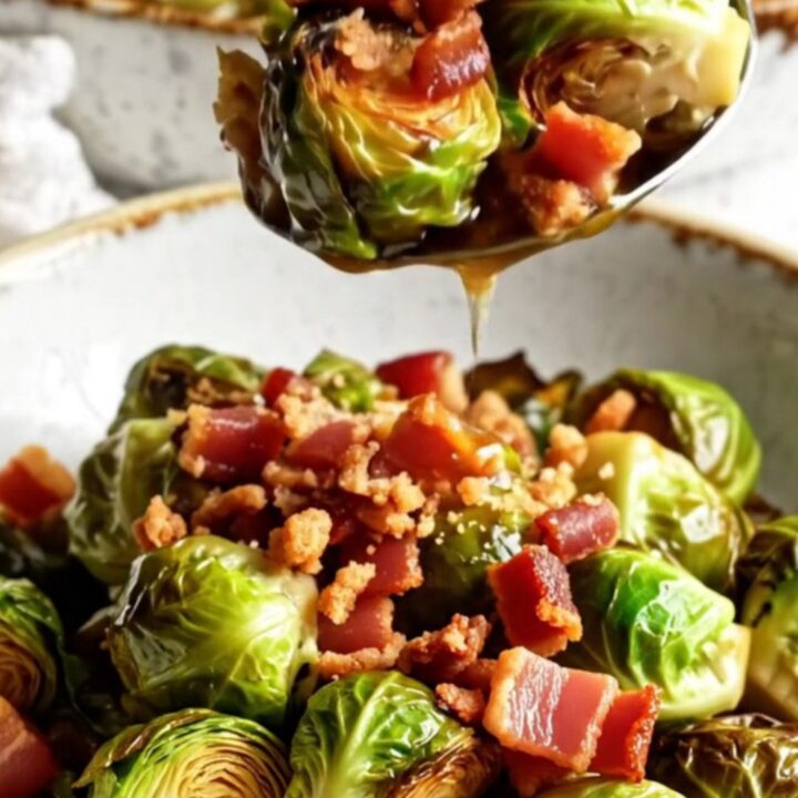 Crispy honey sriracha Brussels sprouts with bacon bits in a glossy glaze, served in a bowl
