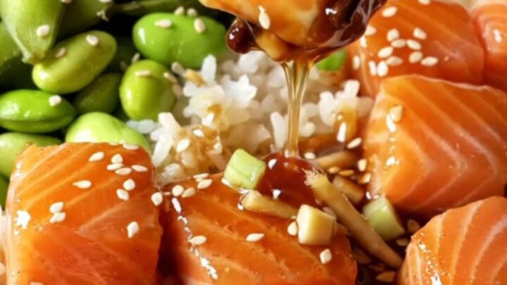 Glazed teriyaki salmon bites over jasmine rice with edamame, topped with sesame seeds.