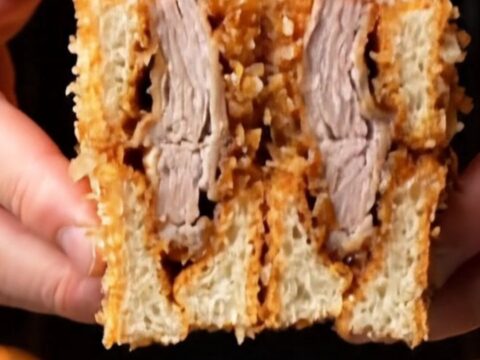 Japanese pork katsu sando sliced in half showing golden panko crust, juicy pork, and cabbage on milk bread